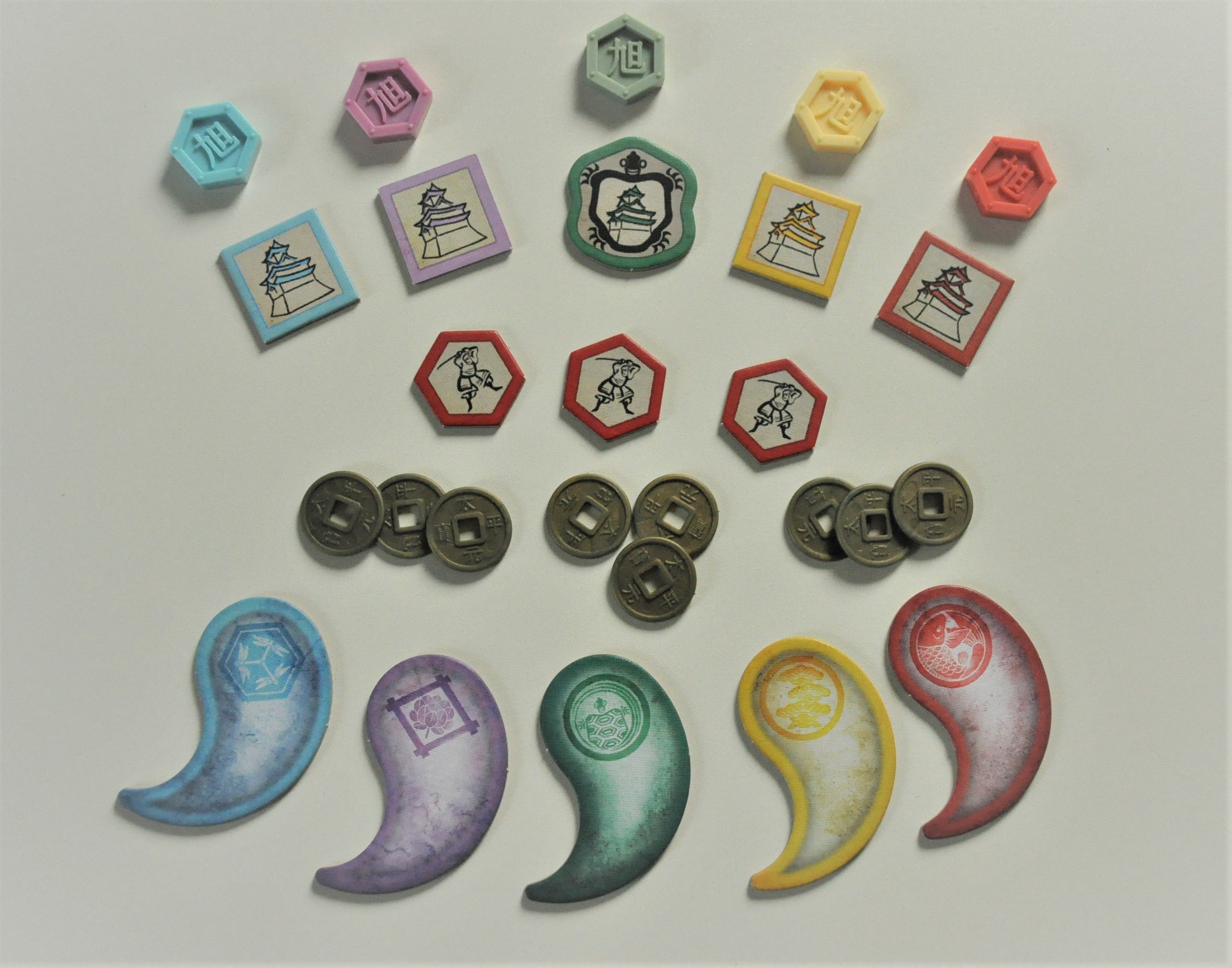 Mniejsze elementy w grze (od góry) znaczniki klanów, żetony twierdz, ronini, monety i żetony sojuszu